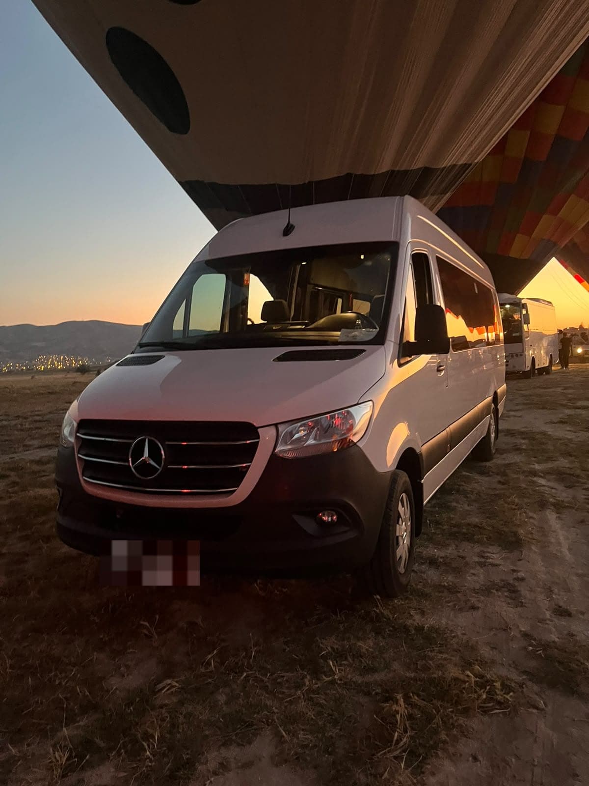 Kapadokya Rota transfer minibus under a hot air balloon at sunrise